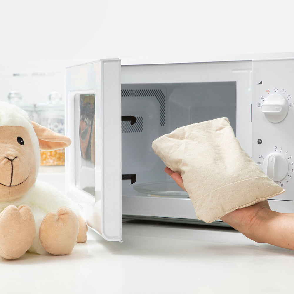 Sheep Soft Toy with Warming and Cooling Effect Wooly InnovaGoods near microwave with warming pouch.