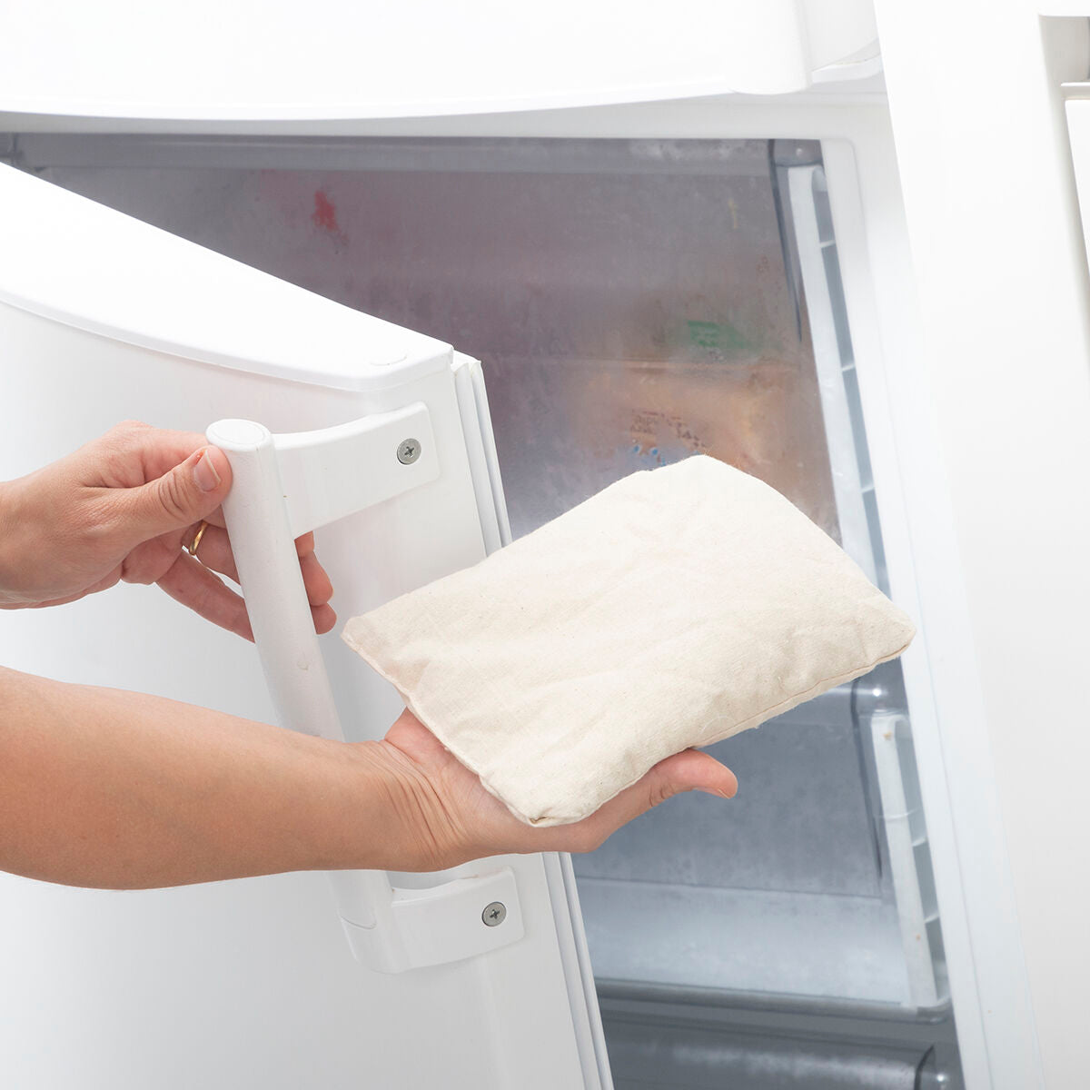 Person placing Sheep Soft Toy with Warming and Cooling Effect Wooly InnovaGoods in refrigerator for cooling.