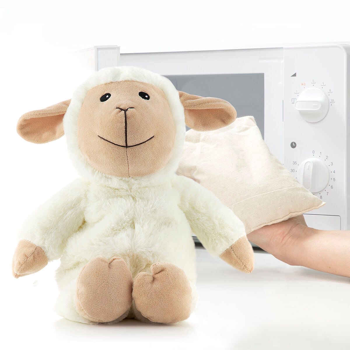 Sheep Soft Toy with Warming and Cooling Effect Wooly InnovaGoods next to a microwave and heating bag.